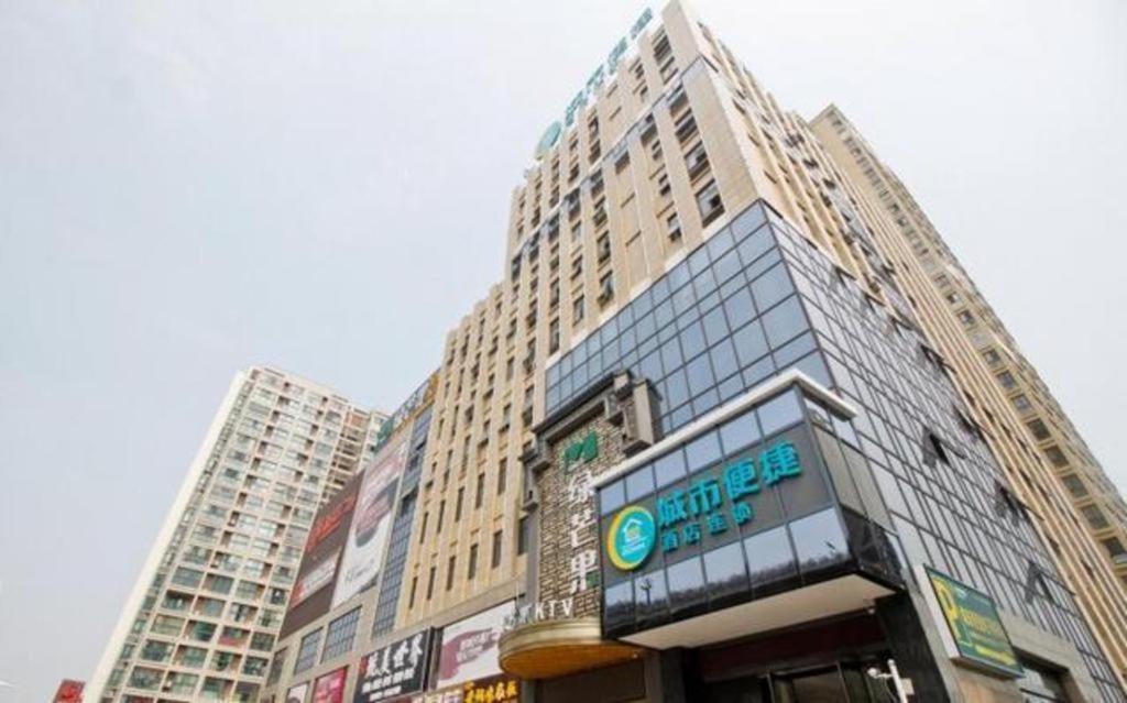 een hoog gebouw met een bord ervoor bij City Comfort Inn Hefei Shuanggang Fuyang Road in Qilitangzhen