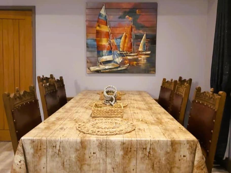 een eettafel met stoelen en een schilderij bij Sailaway - Charming Cowes Cottage in Cowes