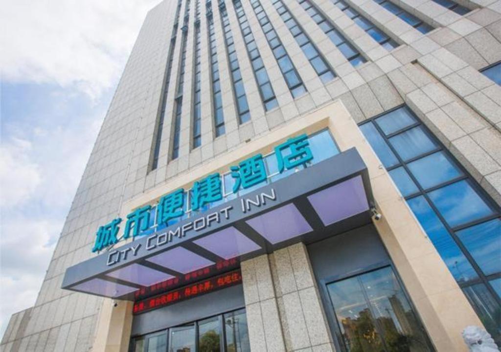 wysoki budynek z znakiem przed nim w obiekcie City Comfort Inn Xuancheng Wanda Qinglv Guoji w mieście Xuanzhou