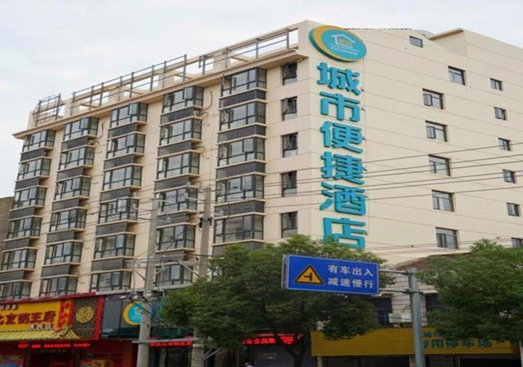 um grande edifício com uma placa em frente em City Comfort Inn Huanggang Huangmei Passenger Station em Huangmei