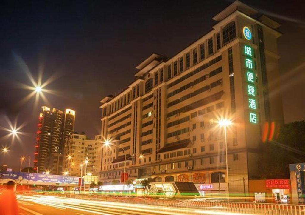 a large building with a clock on it at night at City Comfort Inn Nanning Chaoyang Square Theater Metro Station in Nanning