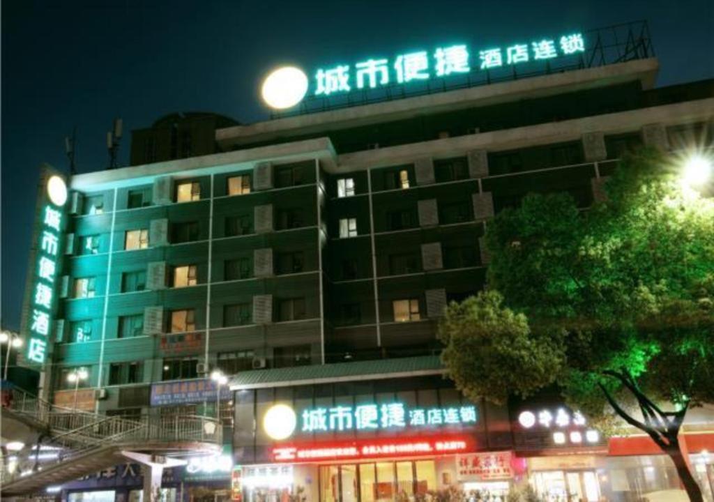 a building with neon signs on it at night at City Comfort Inn Shiyan Renmin Nan Road in Shiyan