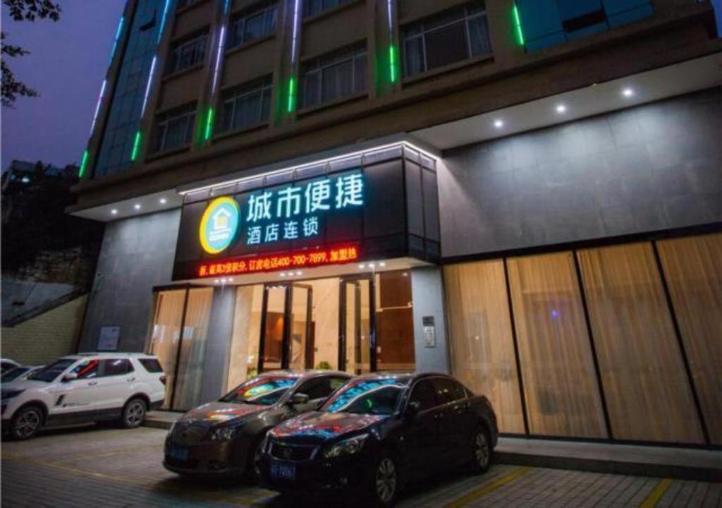 budynek z dwoma samochodami zaparkowanymi przed nim w obiekcie City Comfort Inn Zhanjiang South Zhenchuan Avenue w mieście Zhanjiang