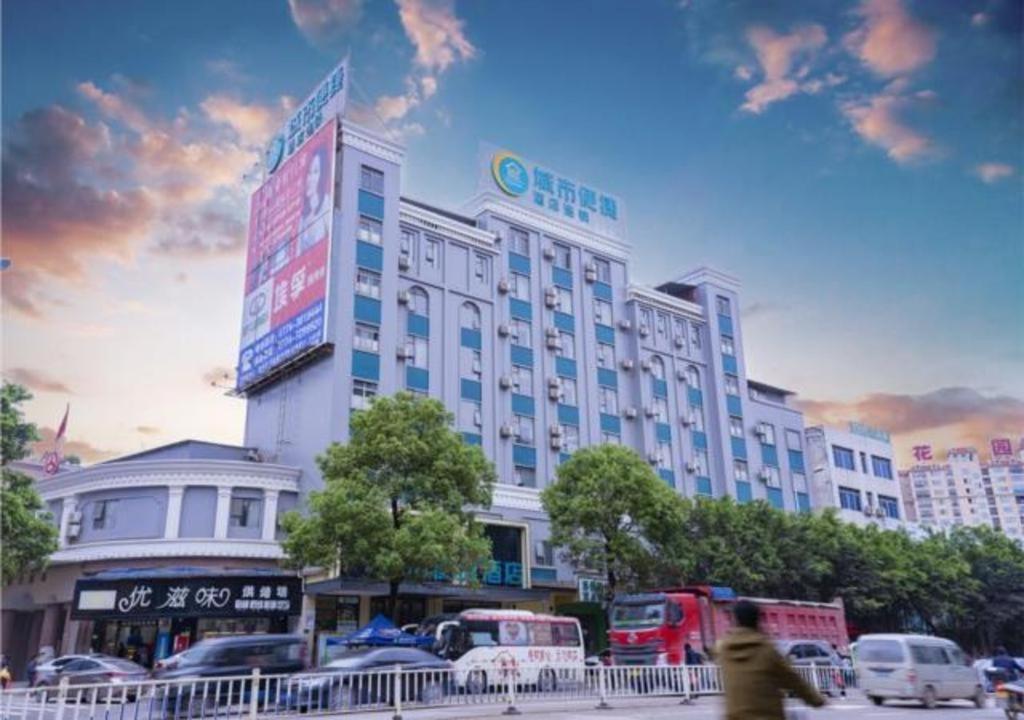 ein großes Gebäude mit davor geparkt in der Unterkunft City Comfort Inn Wuzhou Teng County Bus Station in Tengcheng