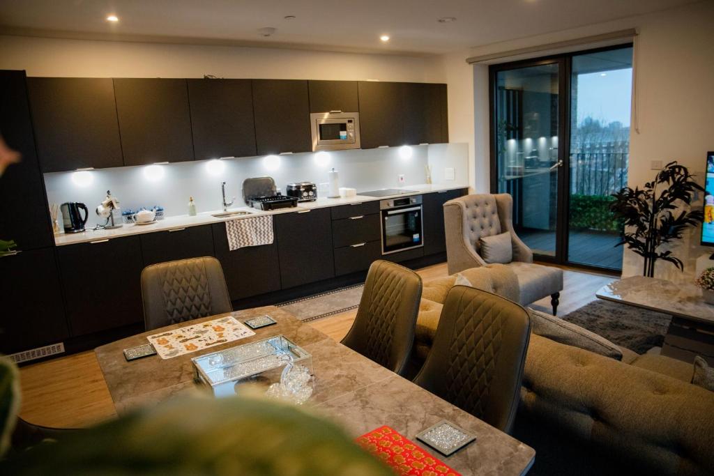 eine Küche und ein Wohnzimmer mit einem Tisch und Stühlen in der Unterkunft Jgb 2-Bed Apartment in London in London