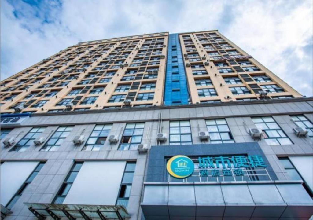 a tall building with a sign on the front of it at City Comfort Inn Yichang Dongshan Three Gorges University Shuiyuecheng in Yichang