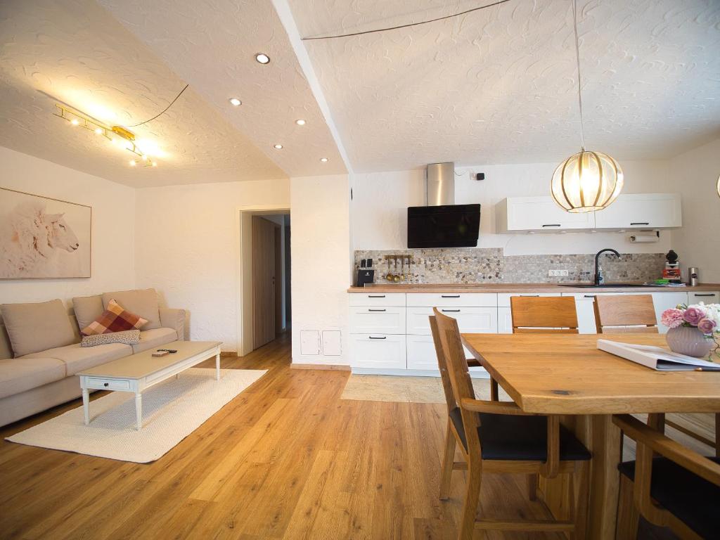 eine Küche und ein Wohnzimmer mit einem Tisch und einem Sofa in der Unterkunft Ferienhäuschen Storchennest in Schönau am Königssee