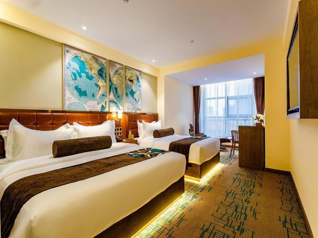 a hotel room with two beds and a large window at James Joyce Coffetel· Xianyang Renmin Road Central Square Store in Xianyang