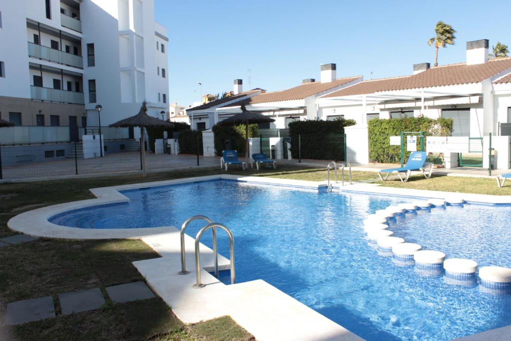uma grande piscina em frente a um edifício em M515 Apartamento Las Dunas Oliva Nova em Oliva