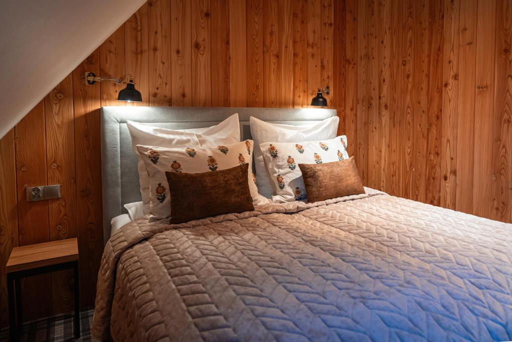 a bedroom with a large bed with wooden walls at Domki Zajazd Furmański " Jacuzzi w ofercie dodatkowo płatnej" in Zakopane