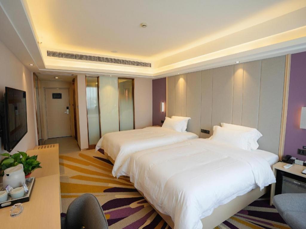 a hotel room with two beds and a television at Lavande Hotels· Yueyang Linxiang Zhongfa in Linxiang