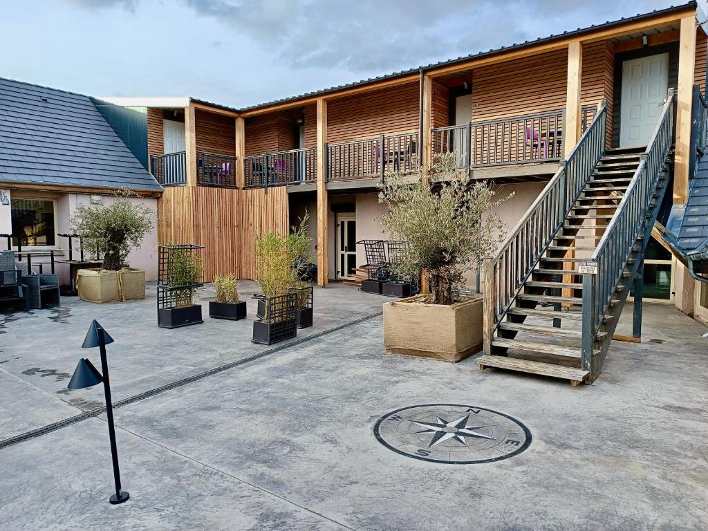 a building with a staircase and a clock in the courtyard at Logis Hôtel Volcan Sancy in Nébouzat