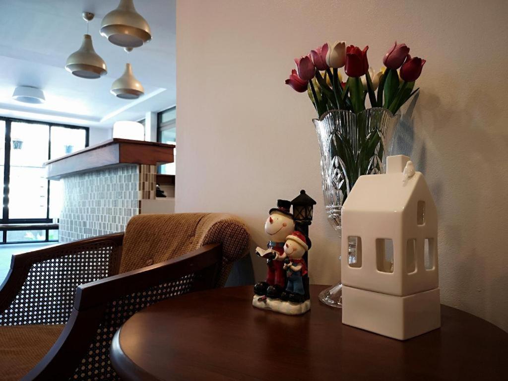 una statuina su un tavolo con una casa e fiori di Baan Nan B&B Hotel a Nan