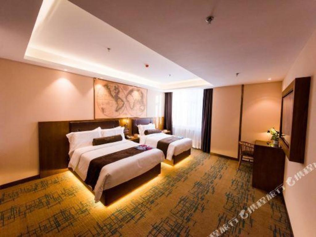 a hotel room with two beds and a window at James Joyce Coffetel Changchun People's Square in Changchun