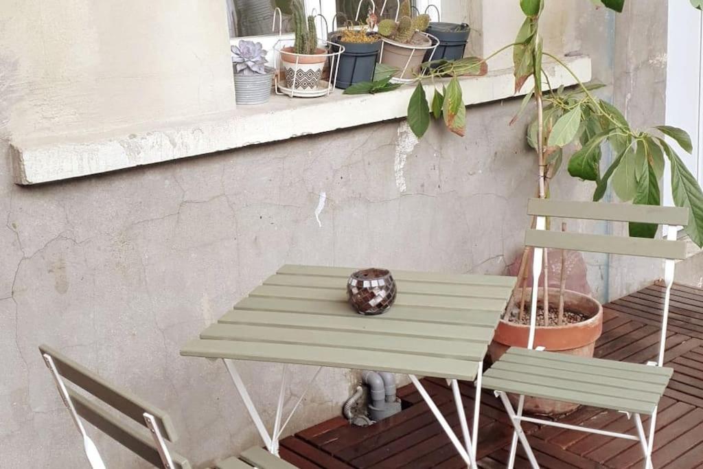 - une table et deux chaises sur une terrasse couverte ornée de plantes dans l'établissement 2-room apartment with terrace near Paris, à Épinay-sur-Seine