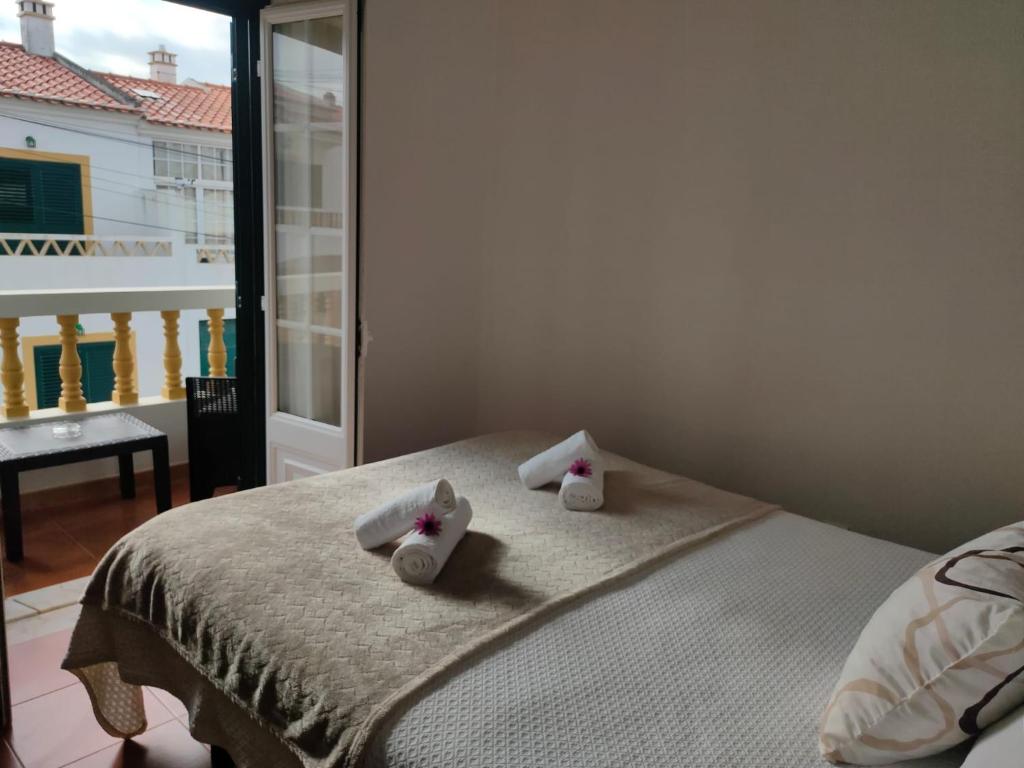 a bedroom with a bed with two towels on it at Lodge & Hike Almograve in Almograve