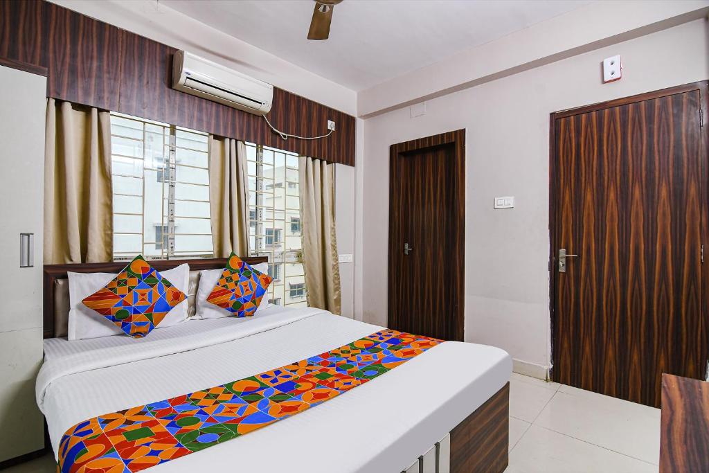 a bedroom with a large bed and a window at FabHotel White House I in Jojera