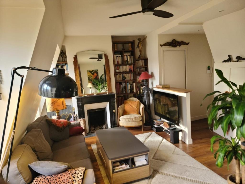 ein Wohnzimmer mit einem Sofa und einem Kamin in der Unterkunft 40m2 flat - 10 min Parc des Princes / Trocadero in Paris