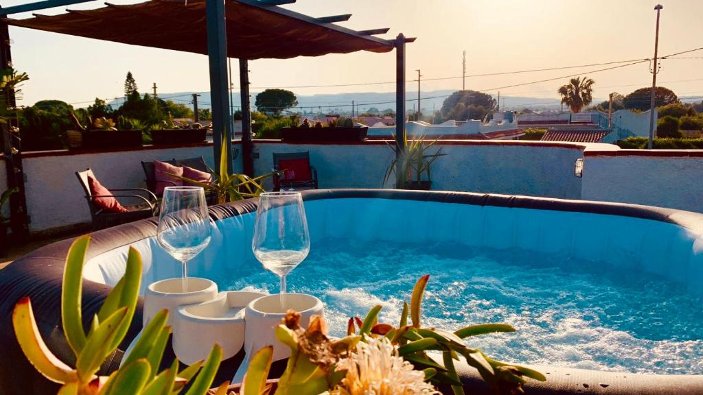 una piscina con bicchieri da vino e cactus di Villa Ale a Fontane Bianche