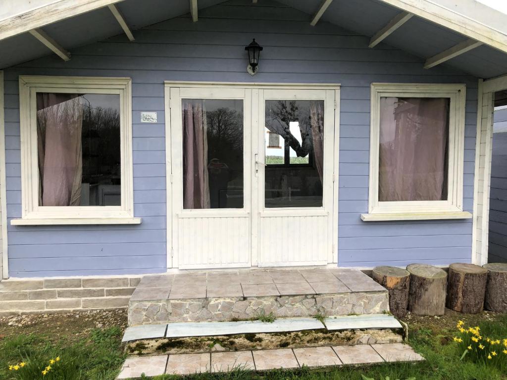 uma casa azul com uma porta branca e janelas em Les Chalets de Babeth et Cathy 
