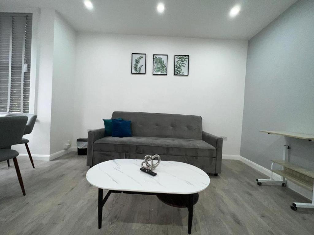 a living room with a couch and a coffee table at Luxe Ground Floor Apt/Free Parking/Private Garden in Redbridge