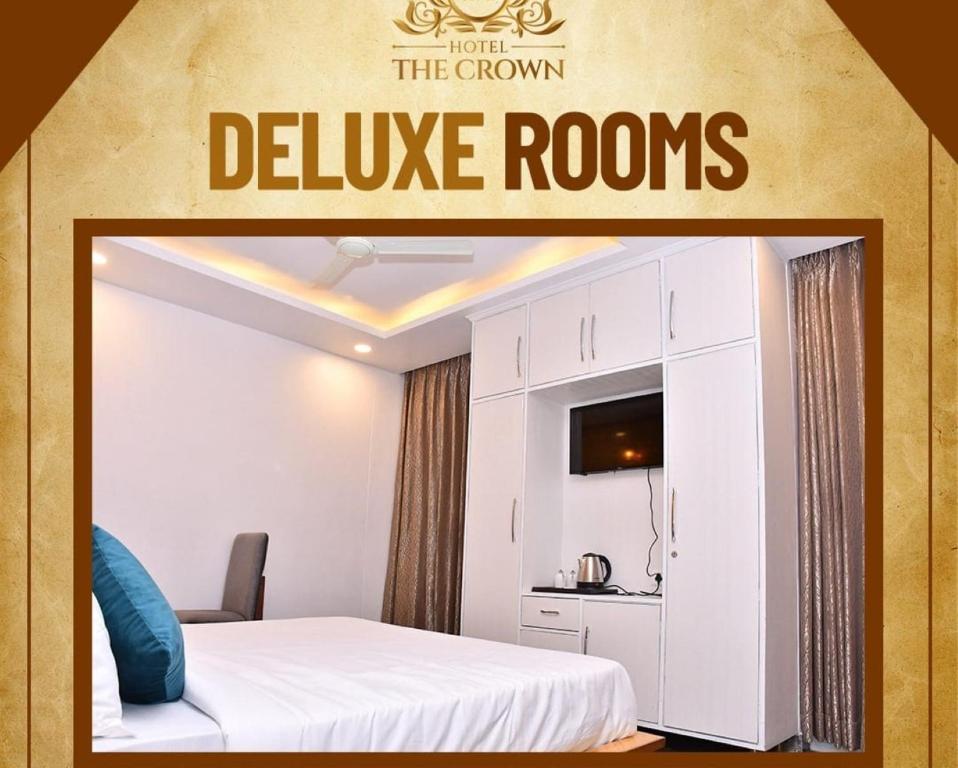 una habitación de hotel con una cama y un cartel que lee las habitaciones de lujo en Hotel The Crown, Dharamshala, en Dharamshala