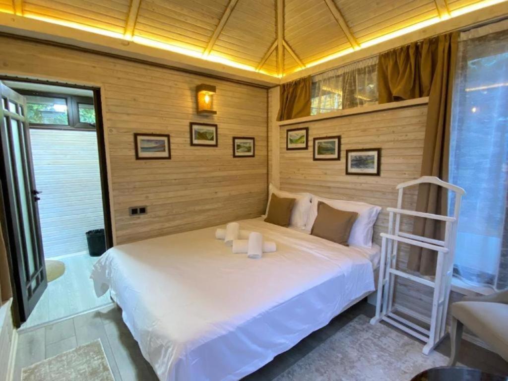 Un dormitorio con una cama blanca con dos velas. en Kausar Hotel en Bishkek