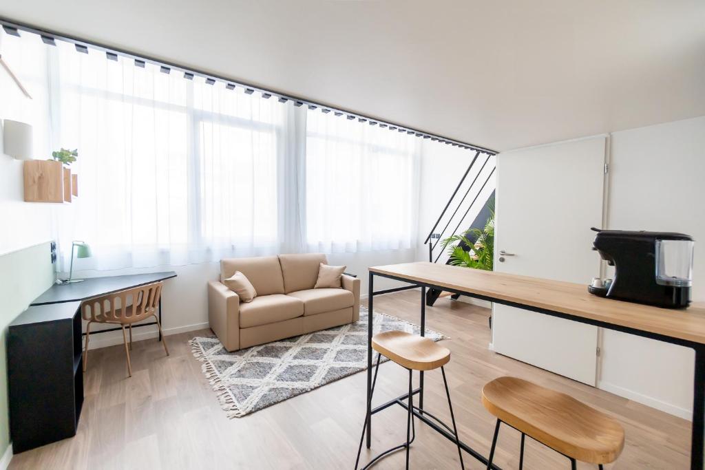 a living room with a couch and a table at ECLA Paris Massy Palaiseau in Palaiseau