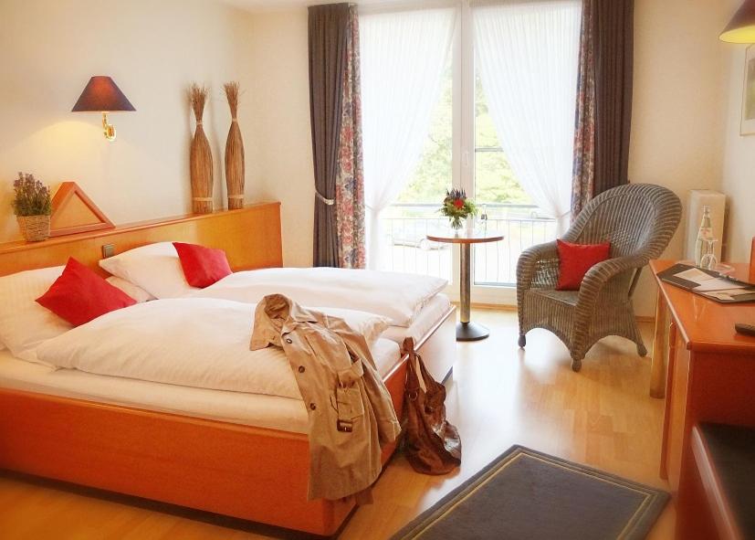 una camera con letto, scrivania e finestra di Auehof Hotel & Restaurant a Garrel