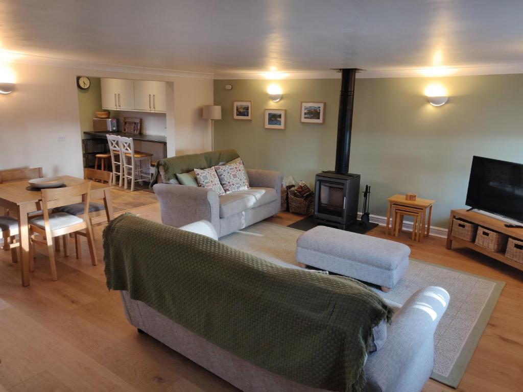a living room with a couch and a table and a television at Weavers Cottage in Haverfordwest