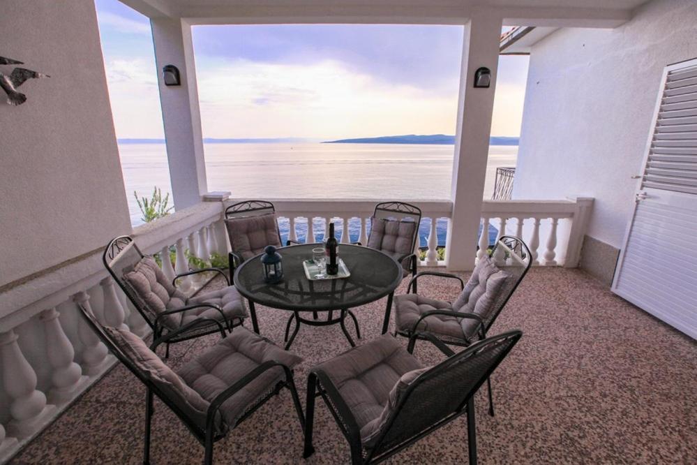 a balcony with a table and chairs and the ocean at Vila Jadran in Promajna