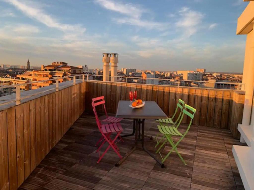 einen Tisch und vier Stühle auf einem Balkon mit Aussicht in der Unterkunft Rooftop terrasse 360° hypercentre in Toulouse