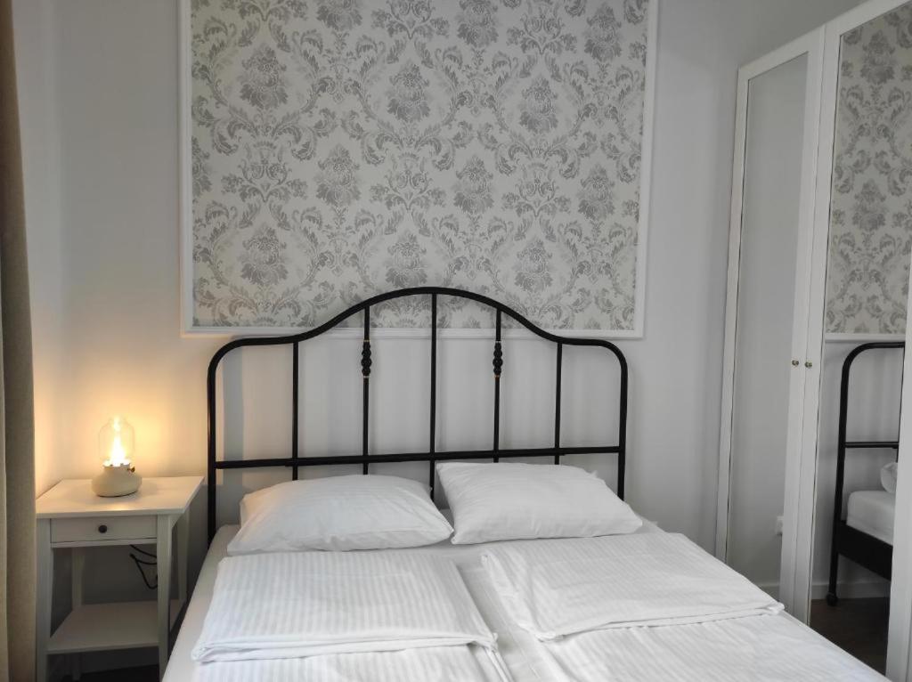 a bedroom with a bed and a wall with a wallpaper at Lawendowy - Apartamenty Smart Projekt in Tarnów