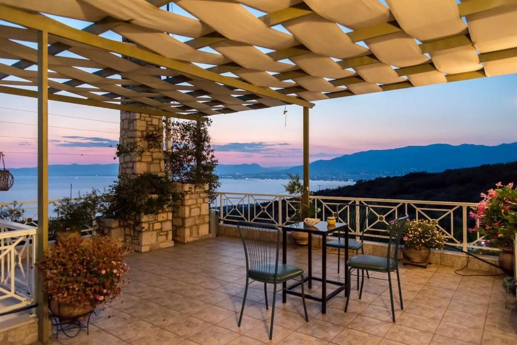 a patio with a table and chairs on a balcony at Villa Needa's - Eros Loft with Infinity Pool in Kalamata