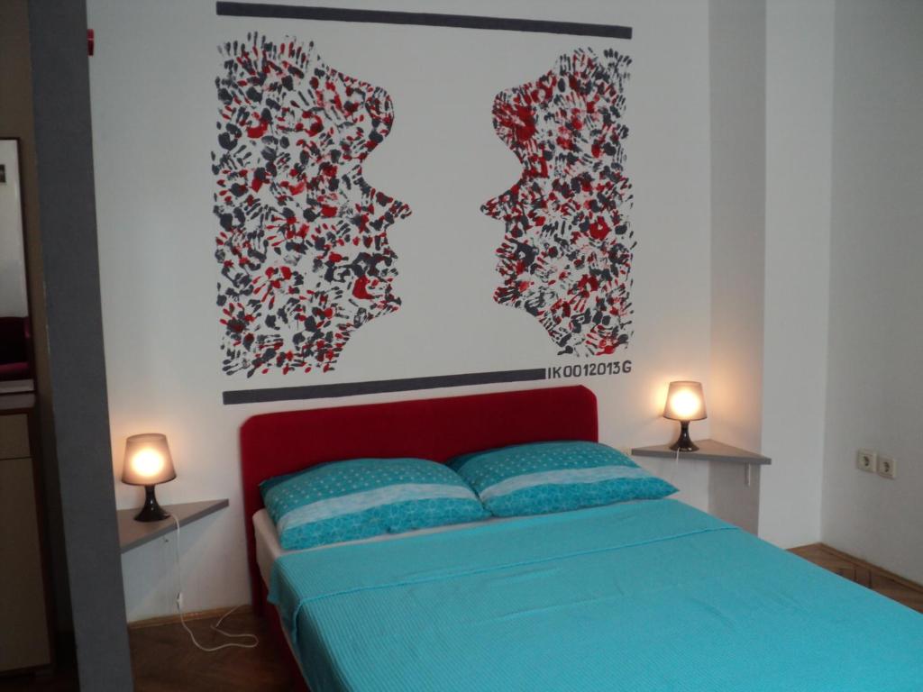 een slaapkamer met een bed en een schilderij aan de muur bij Rooms Sobe ZG in Zagreb