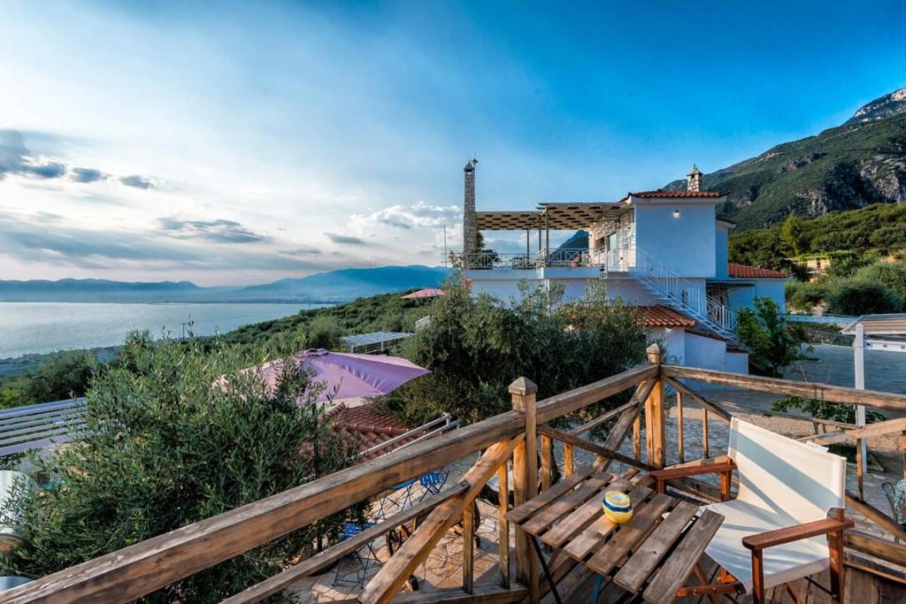 une maison sur une colline avec vue sur l'eau dans l'établissement Villa Needa's - Home Love Retreat by the Pool, à Kalamata