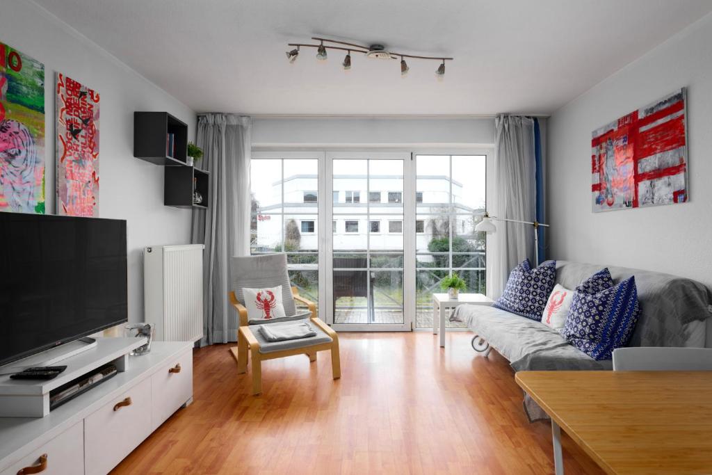 a living room with a couch and a tv at Kapitaenshaus 10 in Laboe