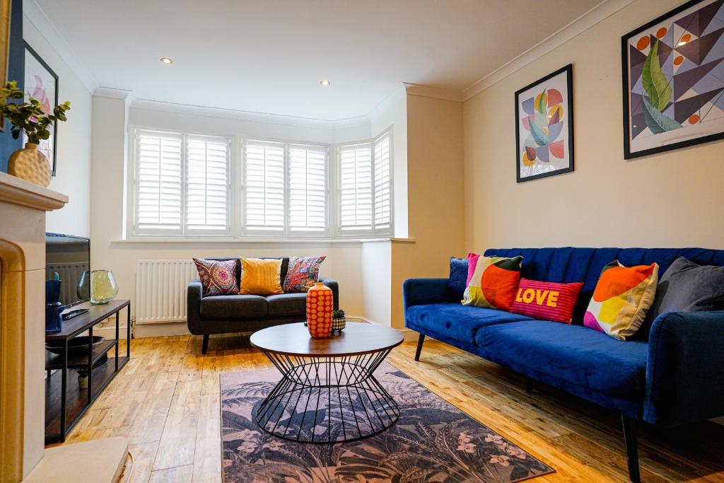 a living room with a blue couch and a table at Southampton 3 Bedroom Luxury House in Southampton