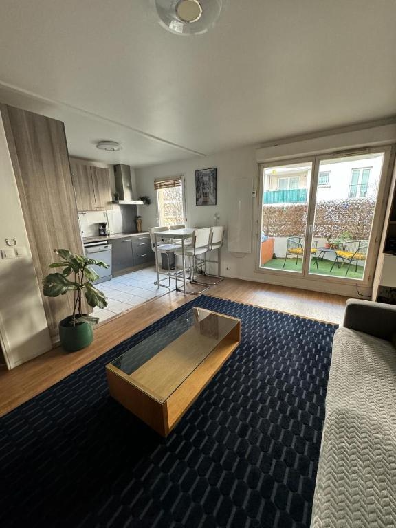 un salon avec un canapé et une table dans l'établissement Le cocon du stade de France, à Saint-Denis