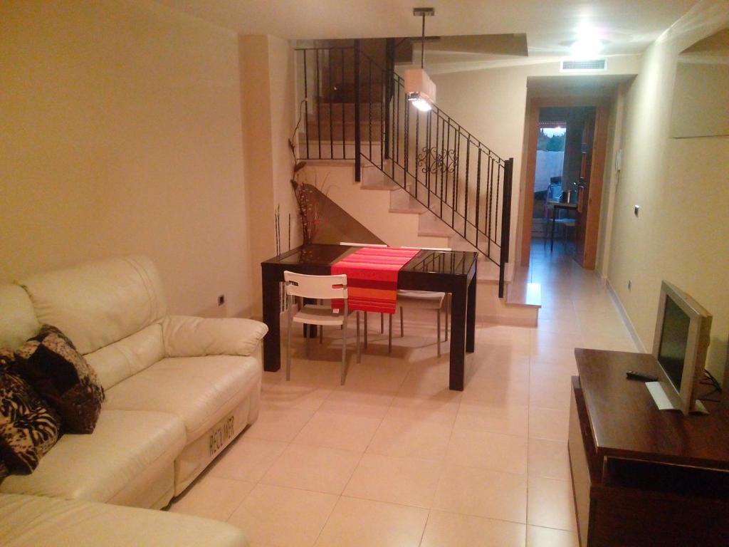 Miramar في ألمازورا: غرفة معيشة مع أريكة وطاولة طعام