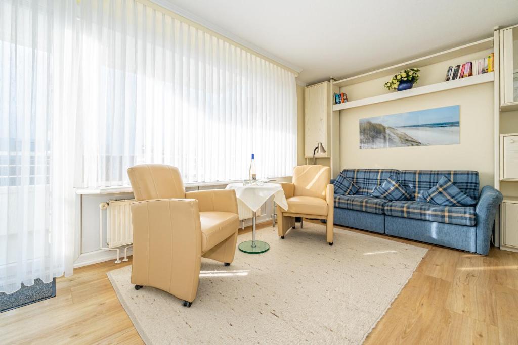 een woonkamer met een bank en een tafel en stoelen bij Haus Sola Bona Sola Bona App 34 in Westerland