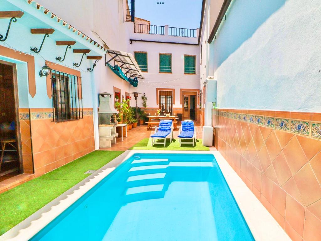 una piscina nel cortile di una casa di SEÑORÍO de MARÍN piscina climatizada exterior ad Arriate