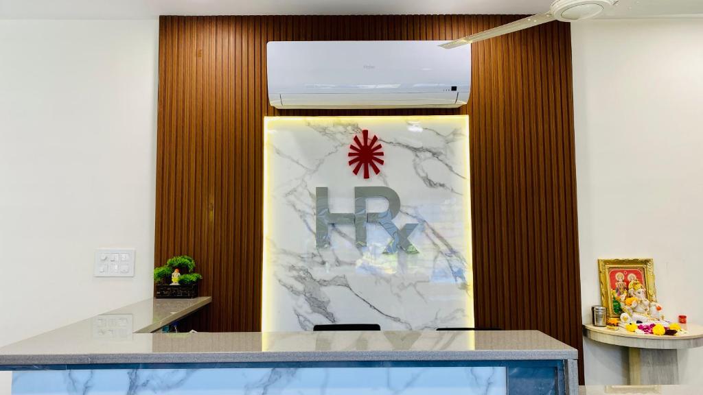 um hall de entrada com uma parede de mármore com uma placa em Hotel Rex em Indore