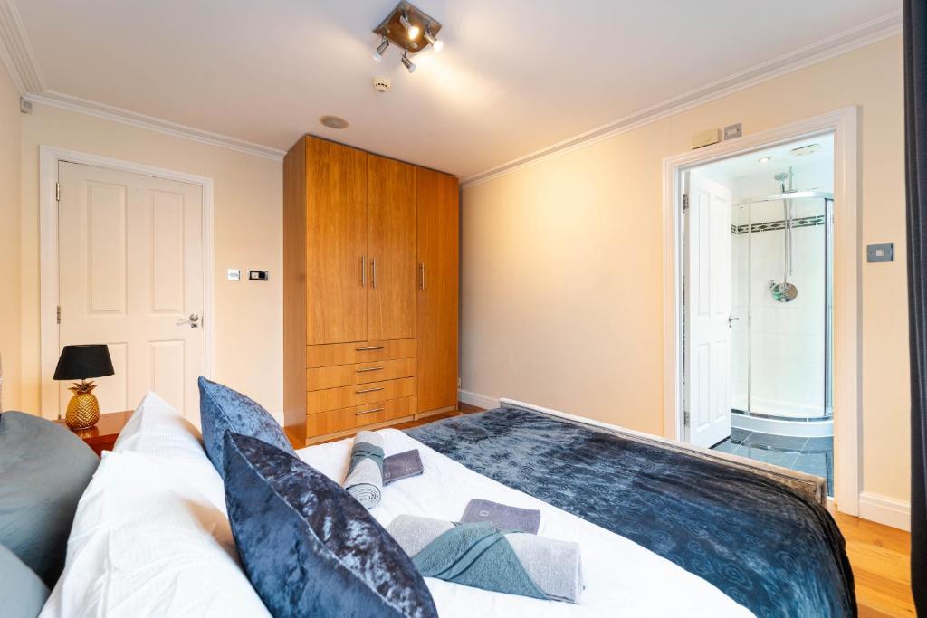 ein Schlafzimmer mit einem großen Bett und einem Holzschrank in der Unterkunft PLACIFY Riverside Penthouse in Chelsea Near King's Road in London