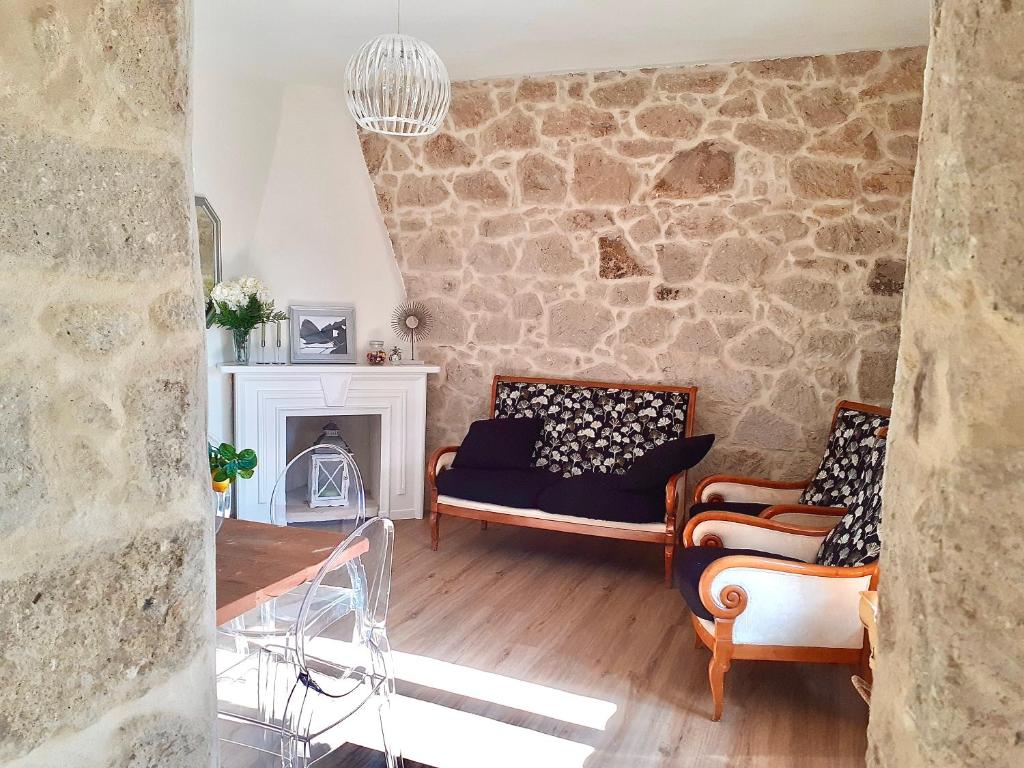 una sala de estar con sofás y una pared de piedra. en Nuovissima Casa in Sardegna!!!!!!!, en Laerru