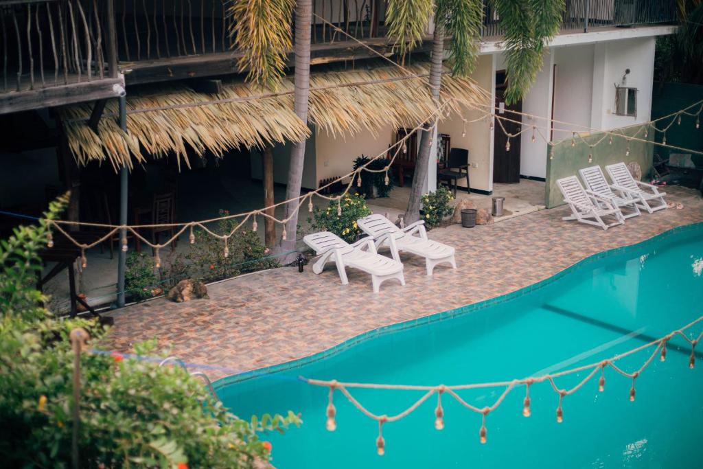 a group of white chairs and a swimming pool at Shell Resort in Arugam Bay