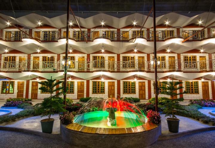 a building with a fountain in the middle of a courtyard at Kea Garden Guest House in Brinchang