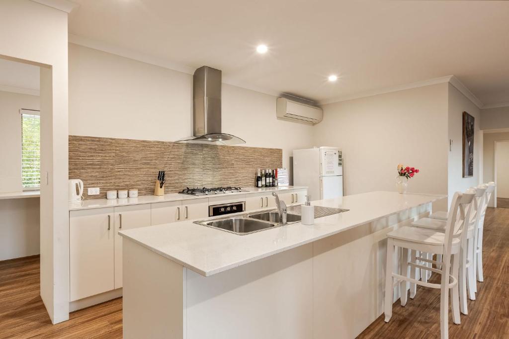 a white kitchen with a sink and a counter at Villa 16 @ Rivendell Winery Estate - Yallingup in Yallingup Siding