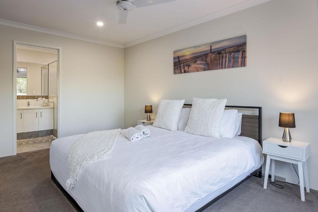 a bedroom with a large white bed and a bathroom at Villa 16 @ Rivendell Winery Estate - Yallingup in Yallingup Siding