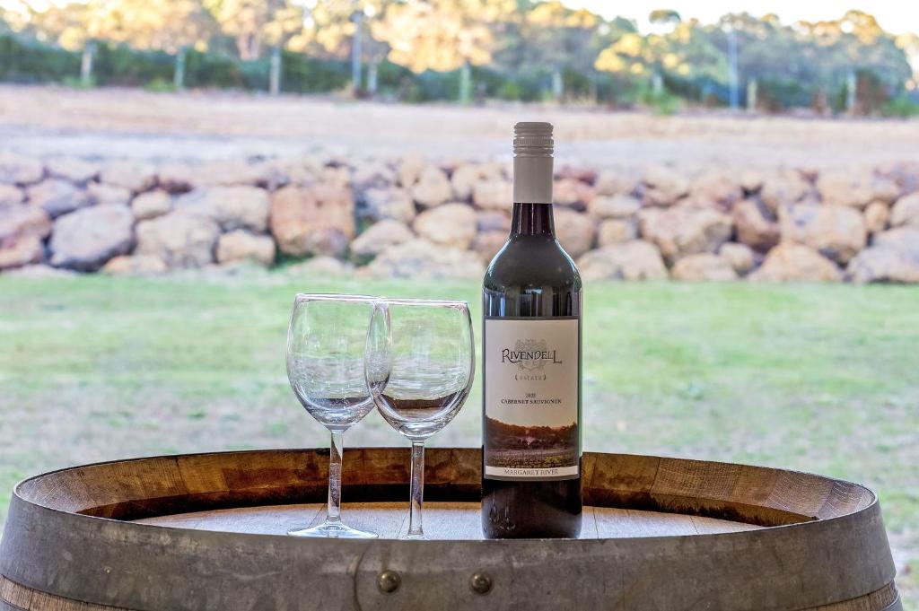a bottle of wine and a glass on a barrel at Villa 16 @ Rivendell Winery Estate - Yallingup in Yallingup Siding